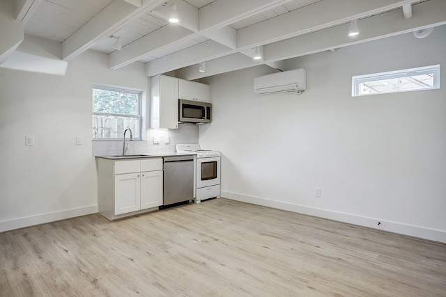 kitchen with stainless steel appliances, a sink, light wood-type flooring, a wall mounted air conditioner, and beamed ceiling