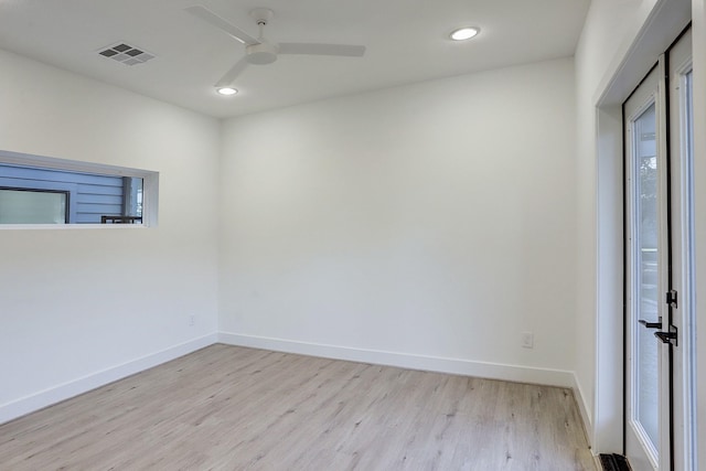 unfurnished room featuring baseboards, light wood-style floors, and visible vents