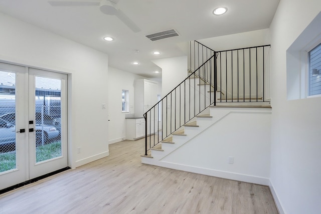 entrance foyer featuring french doors, light wood-style flooring, visible vents, baseboards, and a ceiling fan