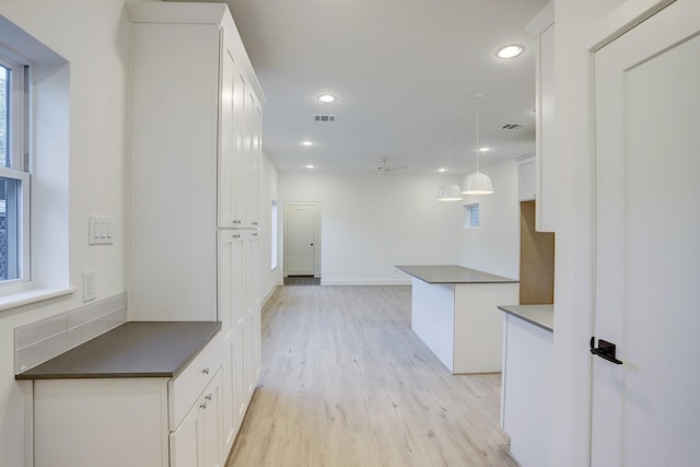 hall featuring light wood-style floors, visible vents, and recessed lighting