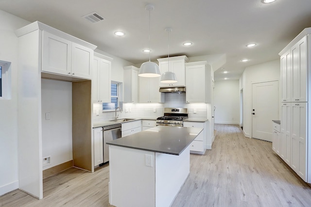 kitchen with stainless steel appliances, baseboards, visible vents, and light wood-style floors