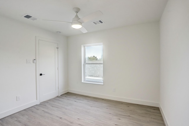 unfurnished room with light wood finished floors, a ceiling fan, and visible vents