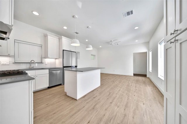 kitchen with dark countertops, a sink, stainless steel appliances, backsplash, and recessed lighting