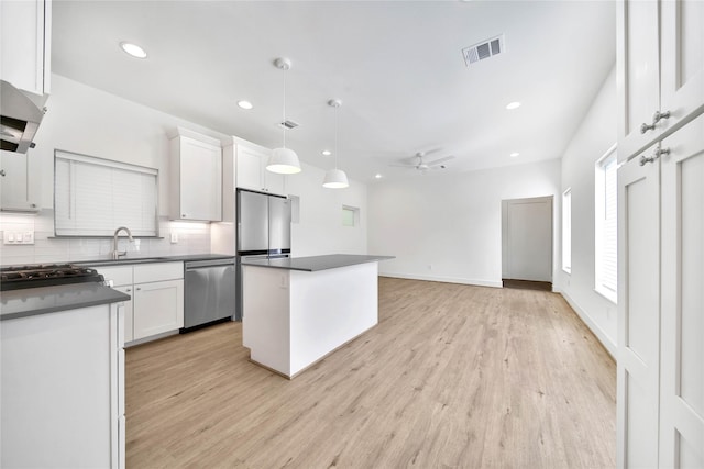 kitchen with a sink, dark countertops, recessed lighting, decorative backsplash, and appliances with stainless steel finishes