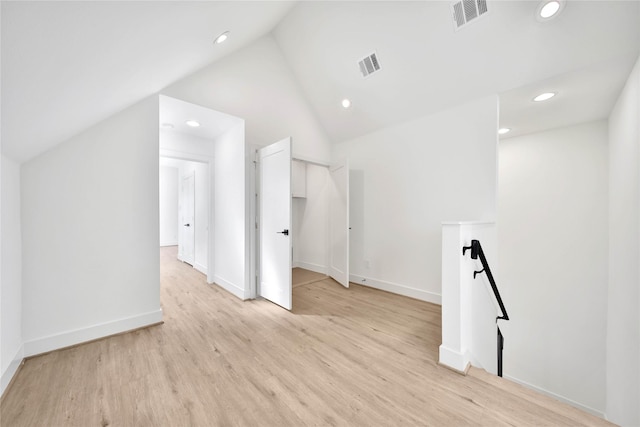 additional living space with vaulted ceiling, light wood finished floors, visible vents, and recessed lighting