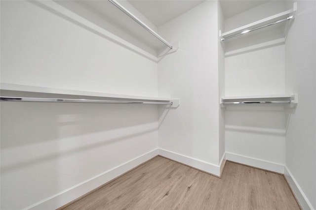 walk in closet with wood finished floors