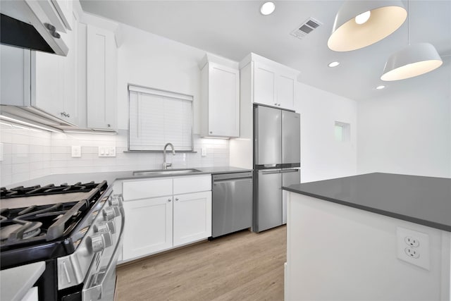 7407 Rusk St Unit B, Houston, TX 77011 - kitchen featuring light wood finished floors, stainless steel appliances, a sink, tasteful backsplash, and visible vents