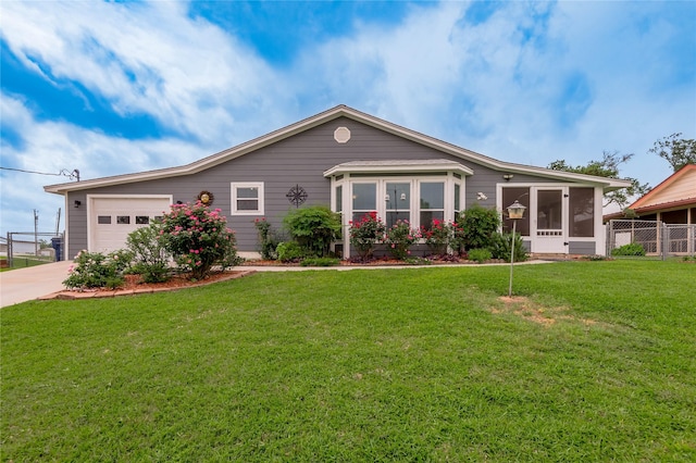 ranch-style house featuring fence, a front lawn, driveway, a sunroom, and a garage