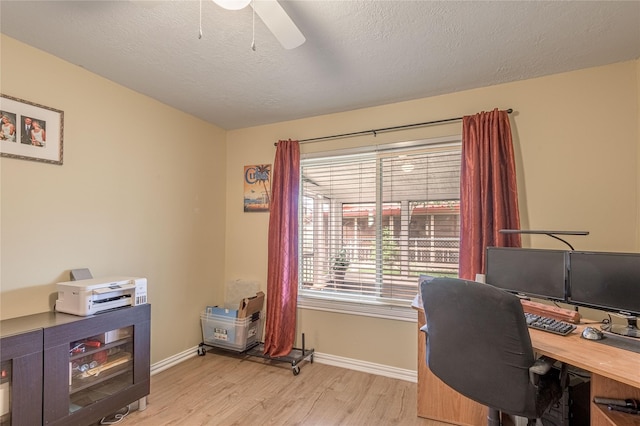 office with ceiling fan, baseboards, a textured ceiling, and light wood-style flooring