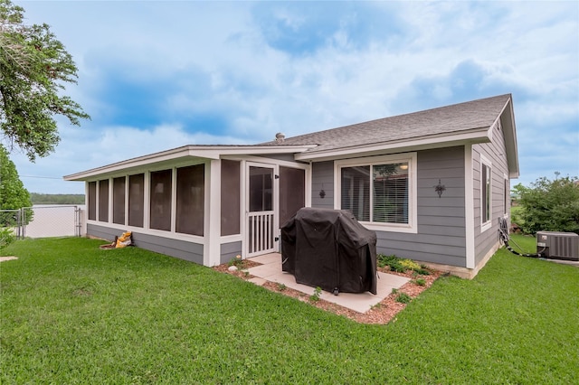 rear view of house with a sunroom, fence, a yard, and cooling unit
