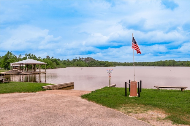 surrounding community featuring a dock, a yard, and a water view