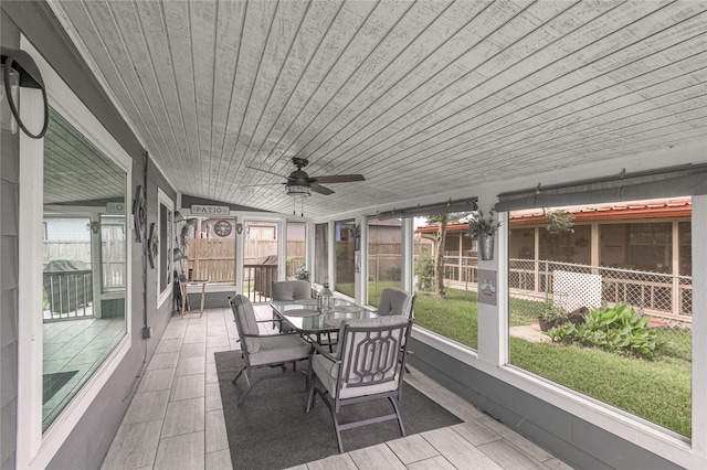 sunroom / solarium featuring ceiling fan, a wealth of natural light, and outdoor dining space