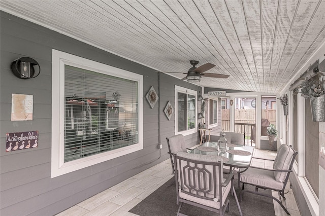 sunroom with outdoor dining area and ceiling fan