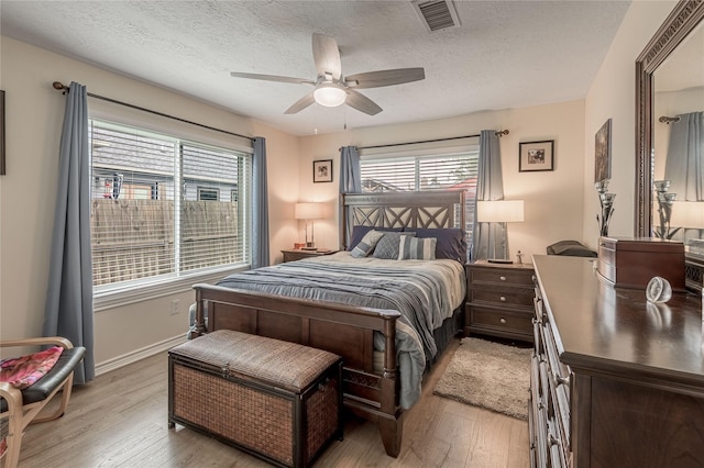bedroom featuring visible vents, light wood-type flooring, and multiple windows