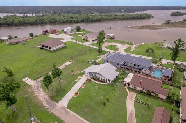 drone / aerial view with a wooded view and a water view