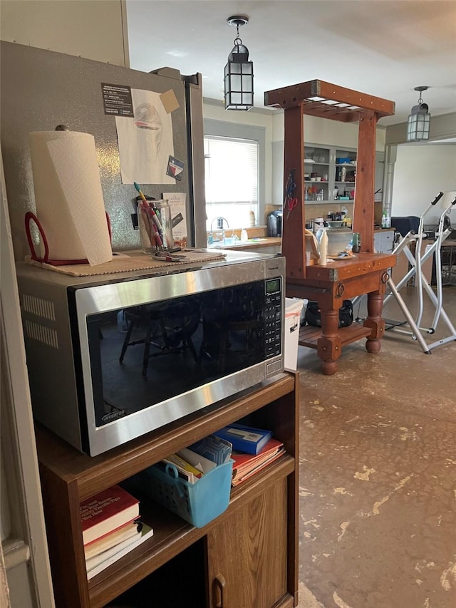 interior space featuring decorative light fixtures and stainless steel microwave