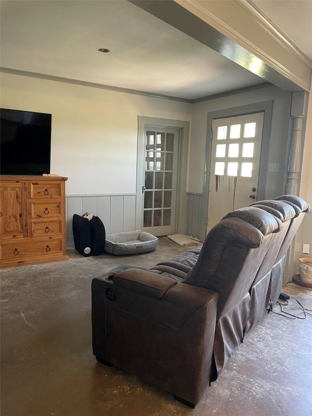 living area featuring a wainscoted wall and ornamental molding