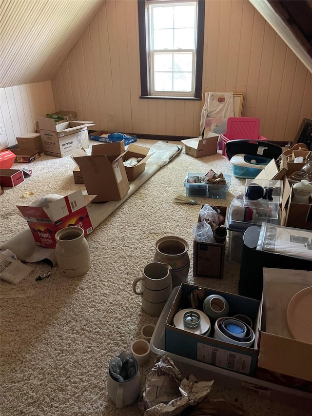 bonus room with wooden walls, vaulted ceiling, and carpet flooring