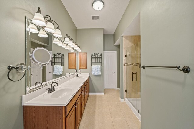 1704 Tempe St, League City, TX 77573 - bathroom featuring tile patterned floors, double vanity, a shower stall, and baseboards