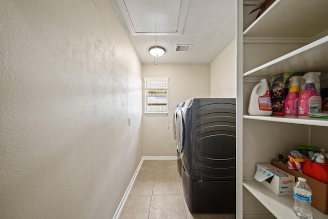 1704 Tempe St, League City, TX 77573 - laundry area featuring attic access, washing machine and clothes dryer, tile patterned floors, baseboards, and a textured ceiling