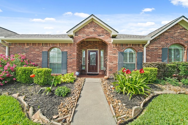 1704 Tempe St, League City, TX 77573 - view of exterior entry featuring brick siding and roof with shingles