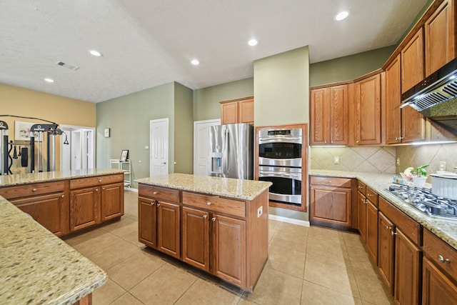 1704 Tempe St, League City, TX 77573 - kitchen with stainless steel appliances, decorative backsplash, brown cabinetry, light tile patterned floors, and recessed lighting