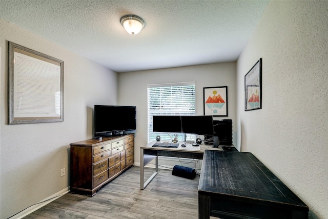 office space with wood finished floors, a textured wall, and a textured ceiling