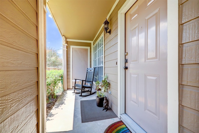view of exterior entry featuring covered porch