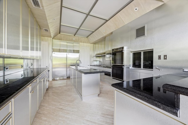 kitchen featuring a sink, visible vents, dobule oven black, and built in fridge