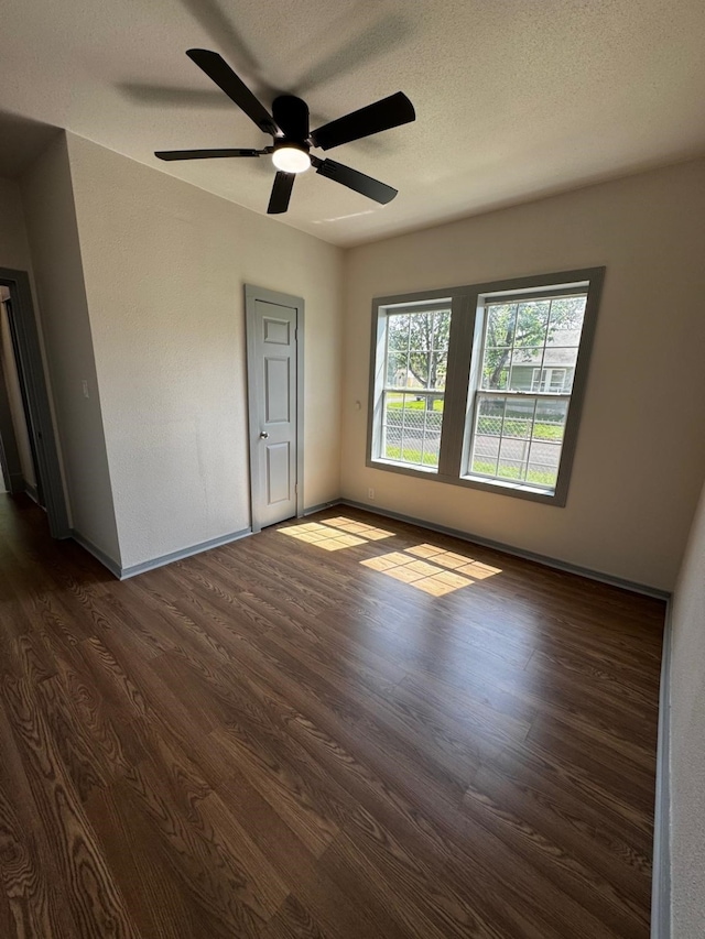 3401 Illinois St, Baytown, TX 77520 - spare room with ceiling fan, baseboards, dark wood-type flooring, and a textured ceiling