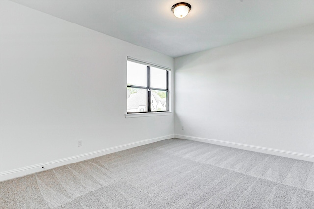 spare room featuring baseboards and carpet flooring
