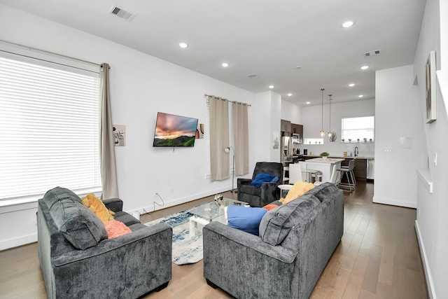 living area featuring wood finished floors, visible vents, and recessed lighting