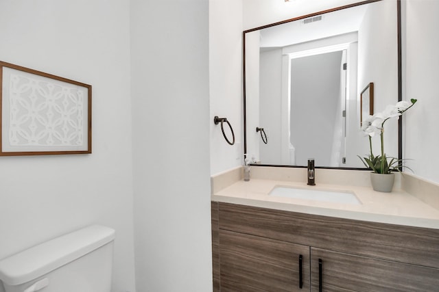 bathroom with visible vents, toilet, and vanity