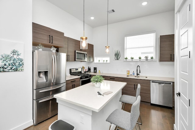 kitchen with a kitchen breakfast bar, light countertops, visible vents, a sink, and appliances with stainless steel finishes
