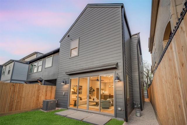 rear view of property featuring cooling unit and fence