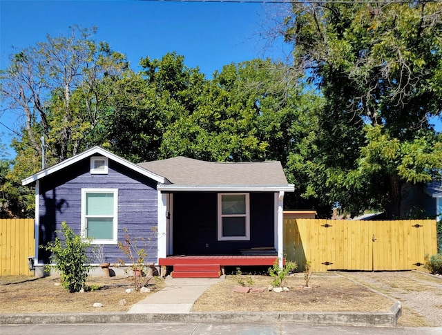 view of front facade with fence, covered porch, and a gate