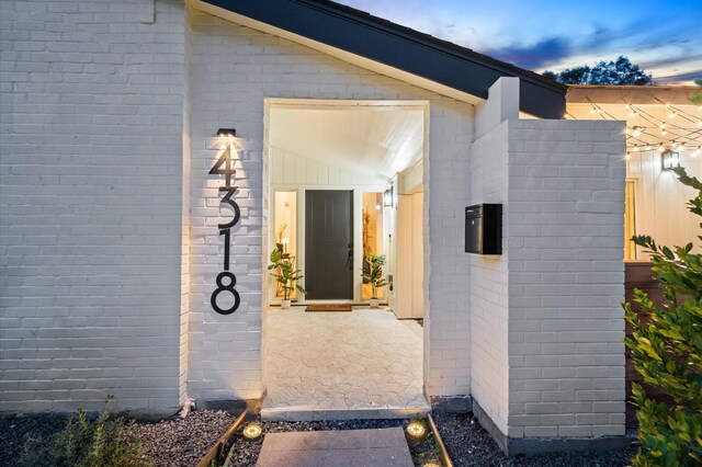 doorway to property featuring brick siding