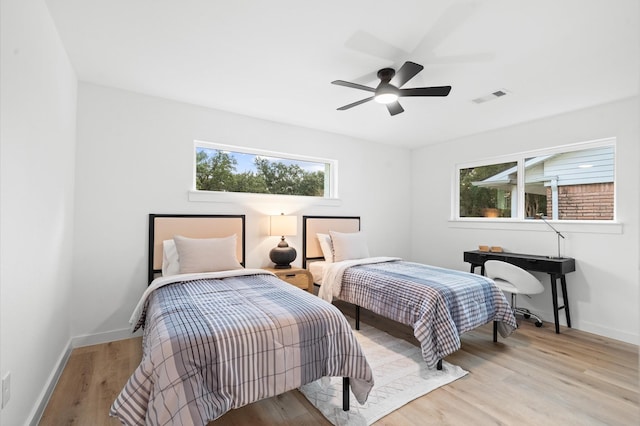 bedroom with light wood-type flooring, visible vents, baseboards, and multiple windows