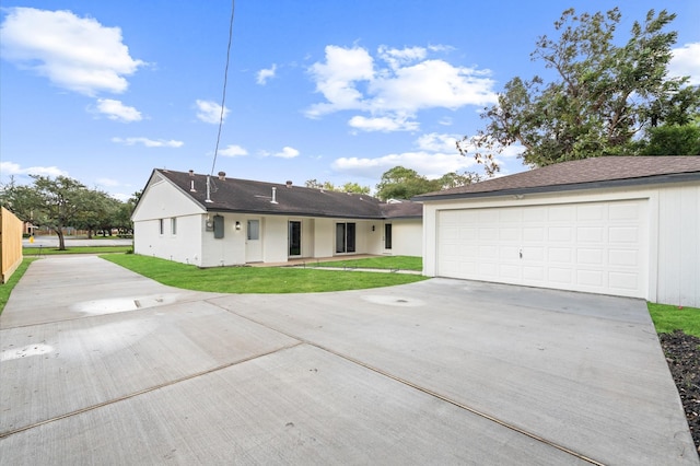 ranch-style house featuring a front lawn, driveway, and a garage