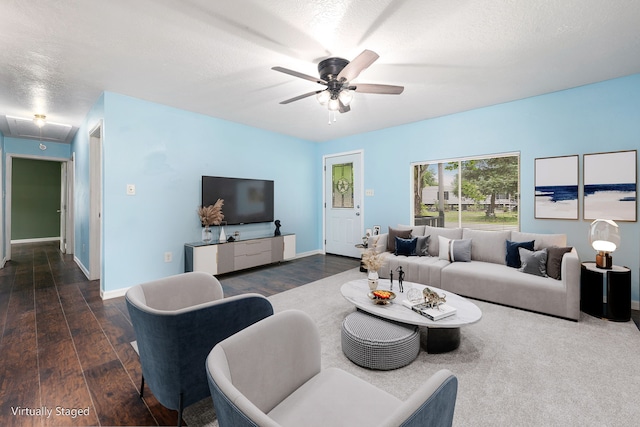 living room featuring baseboards, a ceiling fan, attic access, and dark wood finished floors