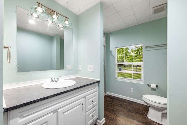 bathroom with visible vents, wood finished floors, vanity, baseboards, and toilet