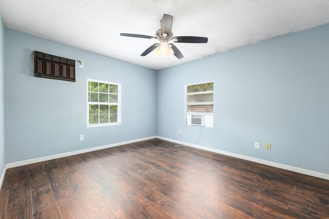 empty room featuring baseboards, a ceiling fan, dark wood-style flooring, and a textured ceiling