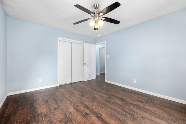 unfurnished bedroom with a ceiling fan, baseboards, dark wood-style floors, and a closet