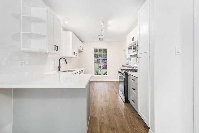 1510 Tarberry Rd, Houston, TX 77088 - kitchen with appliances with stainless steel finishes, a sink, dark wood-style flooring, light countertops, and a peninsula