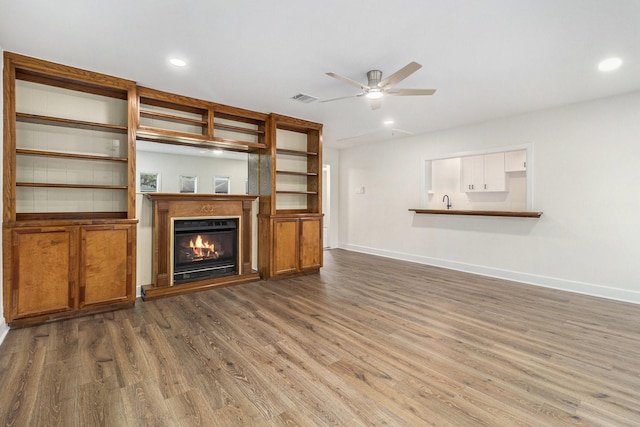 1510 Tarberry Rd, Houston, TX 77088 - unfurnished living room with baseboards, wood finished floors, ceiling fan, a glass covered fireplace, and recessed lighting