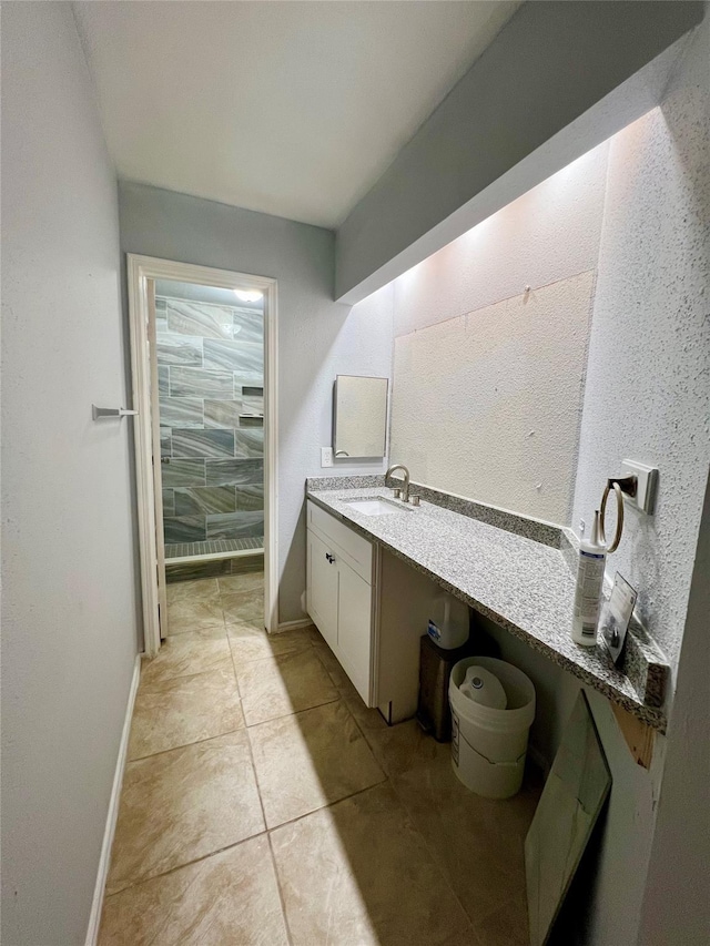 bathroom with tile patterned floors, baseboards, and vanity