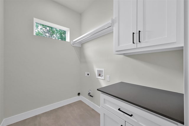 clothes washing area with hookup for a washing machine, cabinet space, hookup for an electric dryer, gas dryer hookup, and baseboards