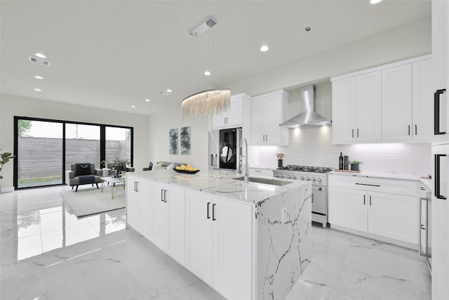 kitchen with visible vents, wall chimney exhaust hood, refrigerator, marble finish floor, and stainless steel stove