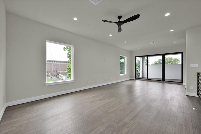 spare room featuring wood finished floors, ceiling fan, recessed lighting, and baseboards