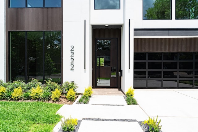 2222 Branard St, Houston, TX 77098 - view of exterior entry with a garage, stucco siding, and driveway